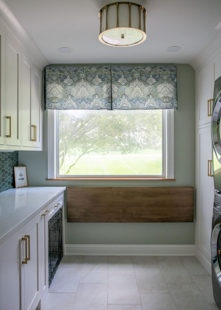 Mudroom with custom built in fold up laundry table and custom window treatments. Lindsey Putzier interior design Hudson Ohio