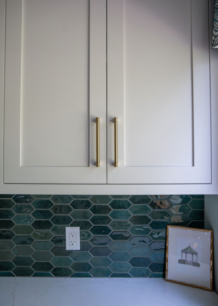 White cabinets in the laundry room and blue backsplash tile. Hudson Ohio Interior design Lindsey Putzier