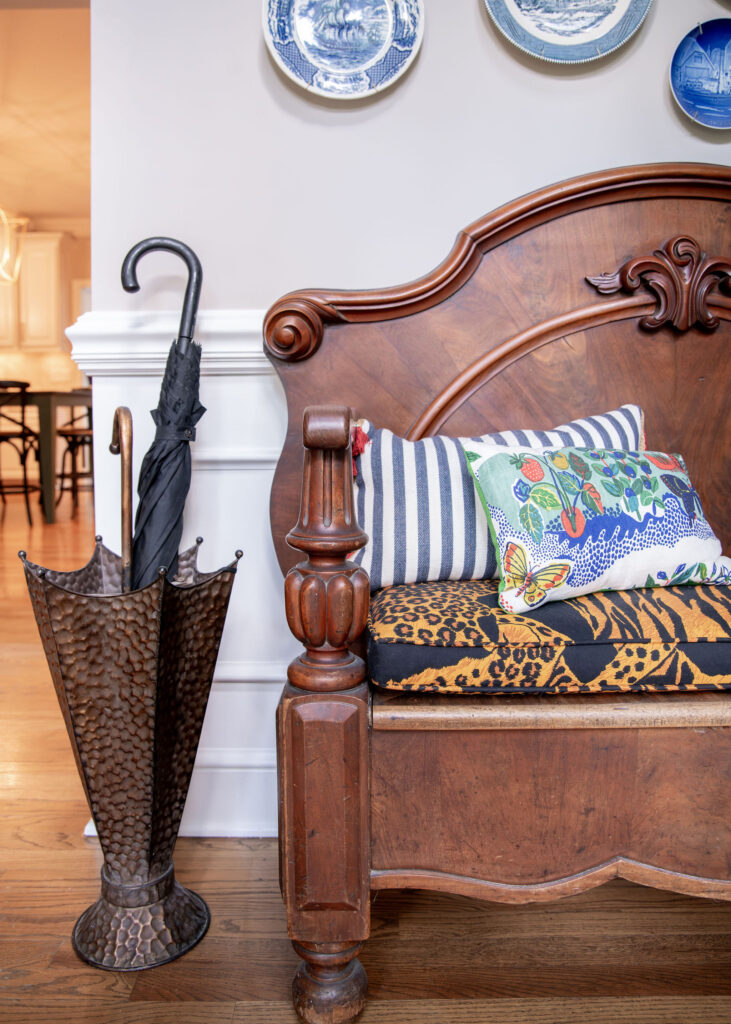 large wooden bench in the front hallway with custom animal print cushion, and custom pillows. Hudson Ohio Interior design Lindsey Putzier