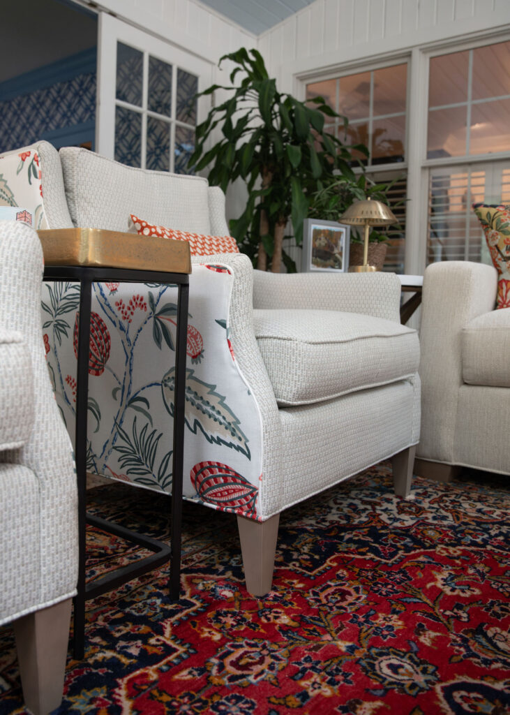 Custom sitting chair in the sunroom with a cream fabric inside and a pattern on the back and outside. Hudson Ohio Interior design Lindsey Putzier