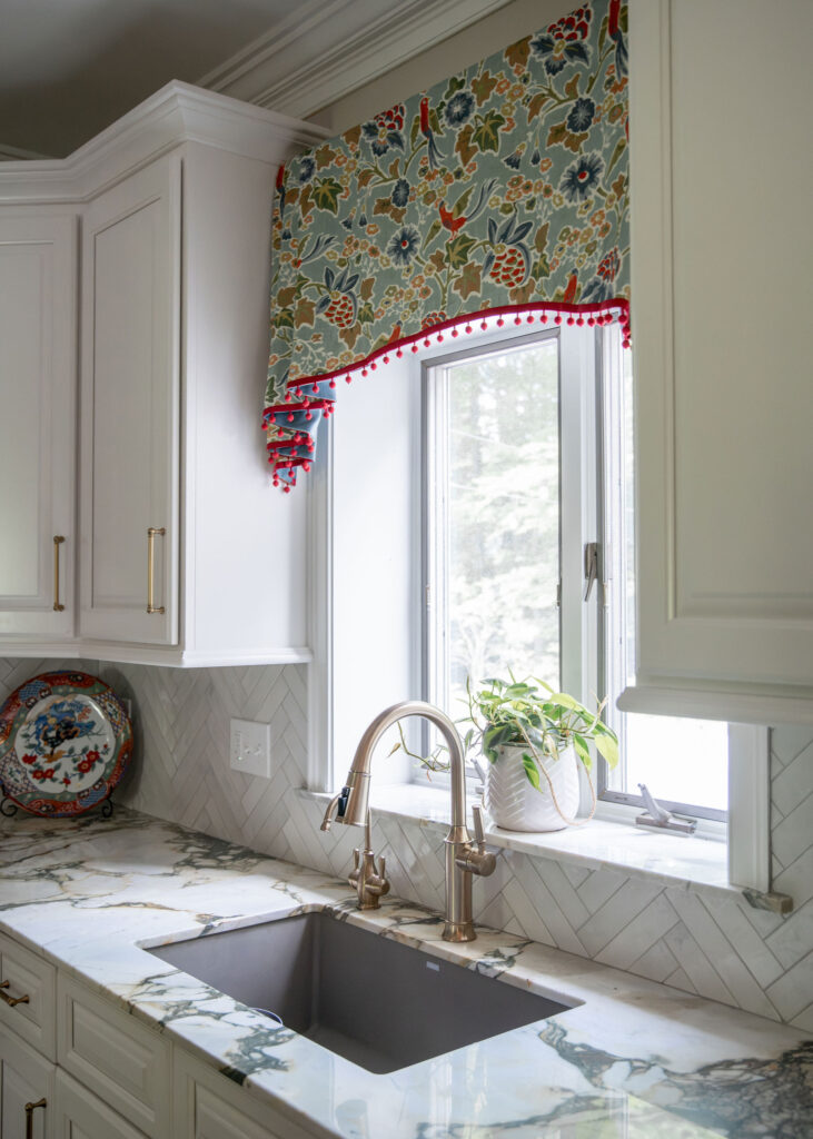 Custom window treatment in the kitchen with fringe edge overtop the sink and marble countertops. Hudson Ohio Interior design Lindsey Putzier