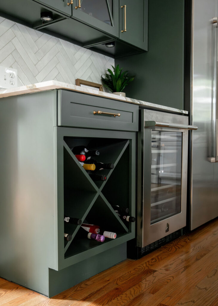 Built in wine storage and beverage cooler in the kitchen with green cabinetry. Lindsey Putzier interior design Hudson Ohio 