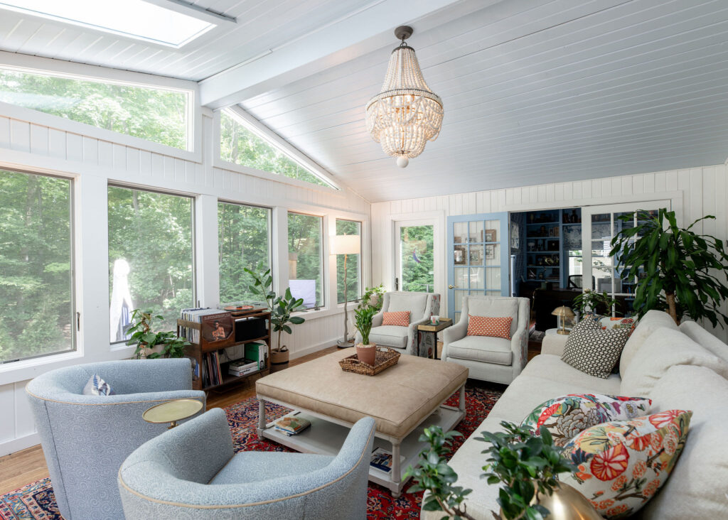After of the sunroom with lbright white walls and ceiling, and custom built furniture. Hudson Ohio Interior design Lindsey Putzier