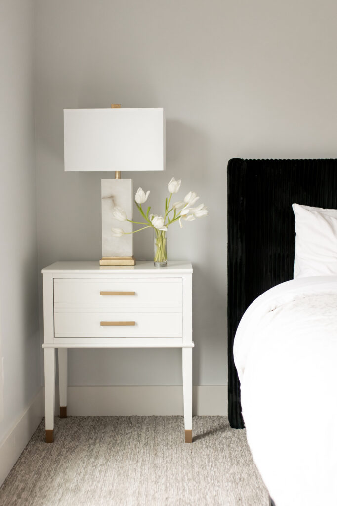 Bedroom with white side table and fresh florals. Lindsey Putzier interior design Hudson Ohio