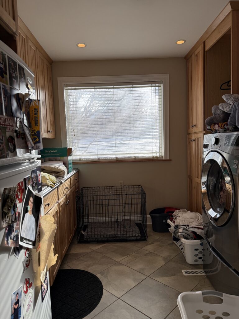 Before of the laundry room with warm wooden cabinets and tile floors. Hudson Ohio Interior design Lindsey Putzier