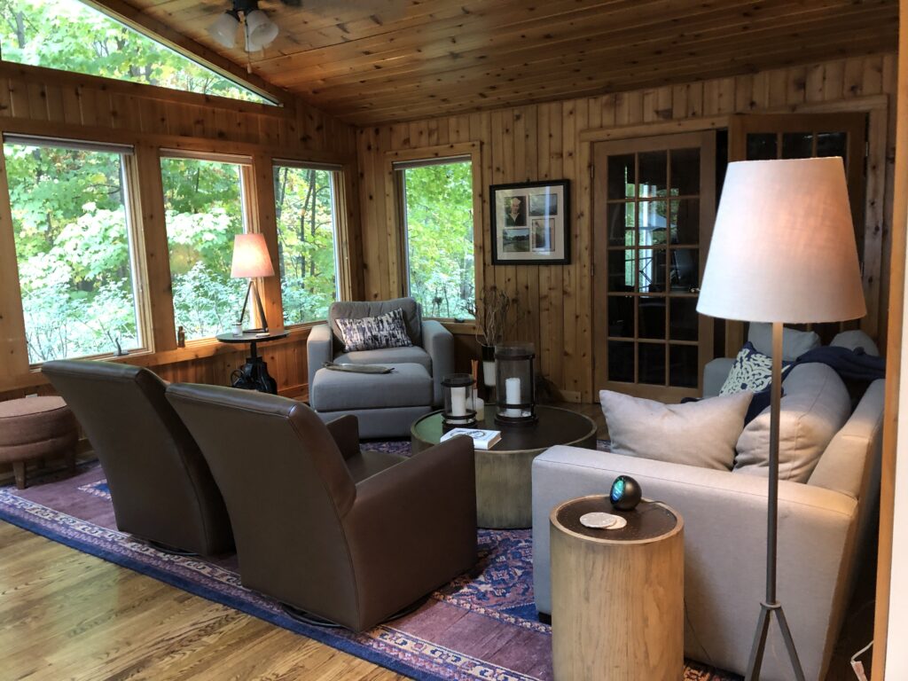 Before of the sunroom with dark wooden walls and dark furniture. Hudson Ohio Interior design Lindsey Putzier